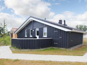una casa negra con techo blanco en 6 person holiday home in GROEMITZ en Grömitz