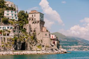 a castle on the side of a mountain in the water at Hotel Degli Amici in Sant'Egidio del Monte Albino