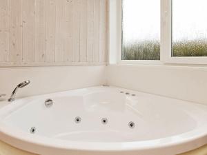 eine weiße Badewanne im Bad mit 2 Fenstern in der Unterkunft 8 person holiday home in Gelting in Gelting