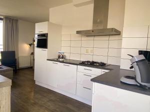 een keuken met witte kasten en een aanrecht bij Hello Zeeland - Appartement Port Scaldis 09-072 in Breskens