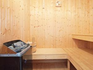 eine Sauna mit einem Herd in einer Holzwand in der Unterkunft Four-Bedroom Holiday home in Otterndorf 18 in Otterndorf