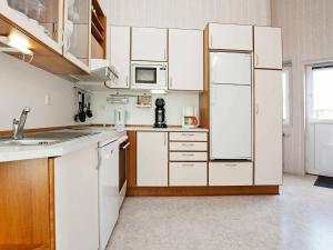 eine Küche mit weißen Schränken und einem weißen Kühlschrank in der Unterkunft Four-Bedroom Holiday home in Otterndorf 18 in Otterndorf