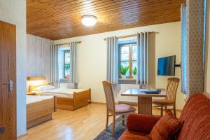 a bedroom with a bed and a desk with a table at Gasthof Weißer Schwan in Windischeschenbach