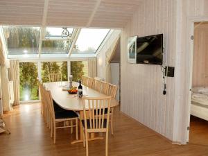 comedor con mesa, sillas y TV en Four-Bedroom Holiday home in Otterndorf 9, en Otterndorf