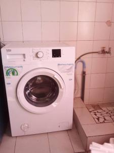 a washing machine in a bathroom with a tiled floor at Chez Eva Jolie in Dakar