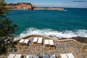 a group of beach chairs and the ocean at Les Roches Brunes in Collioure