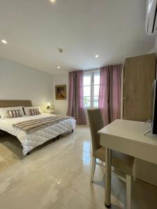 a bedroom with a bed and a table and a desk at La Reggia Seaview Guesthouse in Marsaxlokk