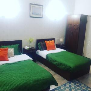 - 2 lits dans une chambre verte et orange dans l'établissement Downtown Inn, au Caire
