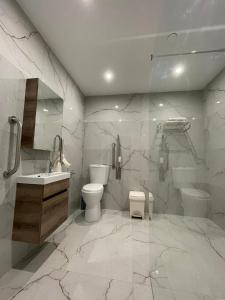 a bathroom with a toilet and a sink and a shower at La Reggia Seaview Guesthouse in Marsaxlokk