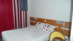 a bed in a room with an american flag at LIBERTY Hôtel Rennes Ouest in Vezin-le-Coquet