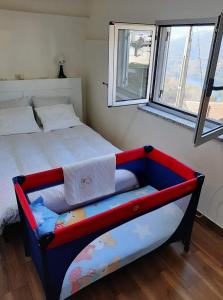un letto con struttura rossa e blu in una camera da letto di Casa do Quitaranda - Gerês a Vieira do Minho Altre 14 foto