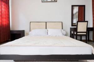 a bedroom with a large white bed with two pillows at Rumah Pahoman Syariah Mitra RedDoorz in Geruntang