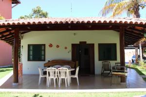 eine Terrasse mit weißen Stühlen und ein Haus in der Unterkunft Hotel Residencial do Mirante in Prado