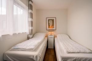 2 Einzelbetten in einem Zimmer mit Fenster in der Unterkunft Appartementencomplex Juliana 154 in De Koog