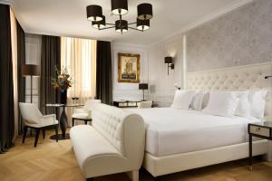 um quarto com uma grande cama branca, uma mesa e cadeiras em Hotel Splendide Royal - The Leading Hotels of the World em Roma