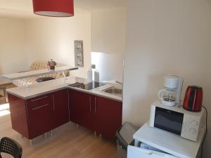 a small kitchen with a sink and a microwave at Appartement en plein centre de Deauville 2éme in Deauville