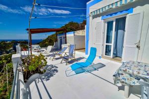 a patio with chairs and a bed and a table at SOLEMAREPONZA Casa Bougainvillea in Ponza
