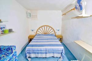 a room with a bed with a blue and white rug at SOLEMAREPONZA Casa Bougainvillea in Ponza