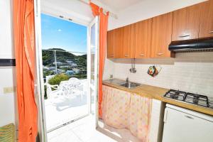 a kitchen with a sink and a view of a balcony at SOLEMAREPONZA Casa Bougainvillea in Ponza