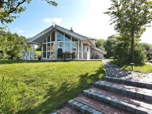 オッテルンドルフにあるThree-Bedroom Holiday home in Otterndorf 13の煉瓦造りの小道とコンサバトリーのある家