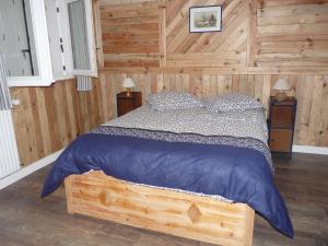 1 dormitorio con 1 cama con pared de madera en Maison Terre et Mer, en Poullan-sur-Mer