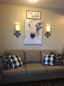 a living room with a couch and a picture of a horse at Crest Country Inn in Williamsburg