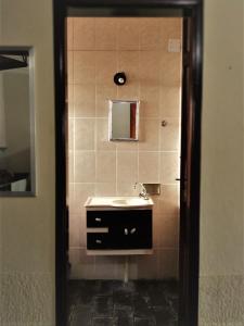a bathroom with a sink and a mirror at Pousada O Caipira in Pouso Alto
