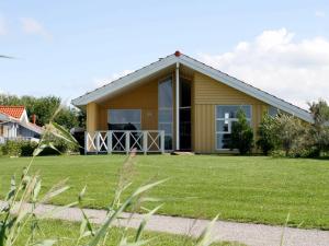 オッテルンドルフにある12 person holiday home in Otterndorfの芝生の広い庭のある家