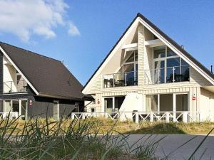 a large white house with a black roof at Two-Bedroom Holiday home in Wendtorf 3 in Wendtorf