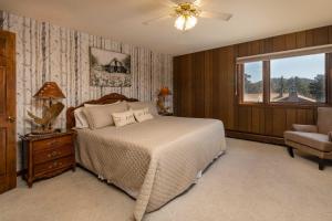 a bedroom with a bed and a chair and a window at Spacious Colorado Retreat with Deck and Mountain Views in Estes Park