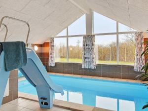 a swimming pool with a slide in a house at 12 person holiday home in Hasselberg in Kappeln