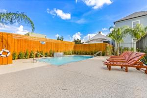 a swimming pool with a bench and a fence at Hosteeva Modern Condo Near Magazine St & Close to FQ in New Orleans +37 photos