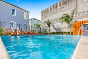 a swimming pool in front of a building at Hosteeva Modern Condo Near Magazine St & Close to FQ in New Orleans