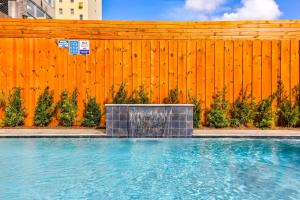 a swimming pool in front of a wooden fence at Hosteeva Modern Condo Near Magazine St & Close to FQ in New Orleans