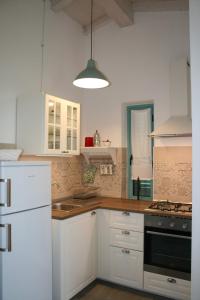 eine Küche mit weißen Schränken und einem weißen Kühlschrank in der Unterkunft Agriturismo podere 678 in Grosseto