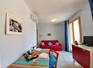 a living room with a table and a red couch at Appartamento La Pergola al Cavo in Cavo
