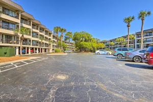 ein Parkplatz vor einem Gebäude mit Palmen in der Unterkunft Coastal Condo with Pool and Direct Beach Access! in Hilton Head Island