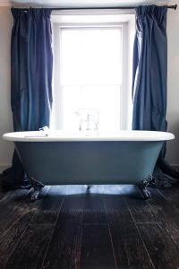 a bath tub sitting in front of a window at The Ram Inn in Lewes