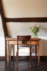 una mesa de madera con un jarrón de flores. en The Ram Inn, en Lewes