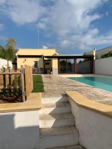 un cortile con piscina e una casa di Appartamento in villa con piscina a 700m dal mare a Lendinuso