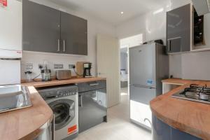 a kitchen with stainless steel appliances and wooden counters at Modern 2 Bedroom Apartment in Morden in London