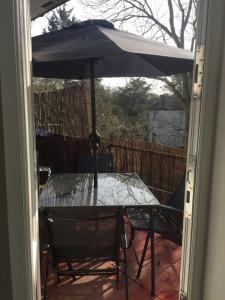 a table and chairs with an umbrella on a patio at Modern 2 Bedroom Apartment in Morden in London