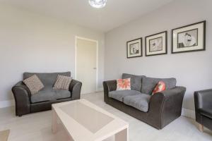 a living room with two chairs and a coffee table at Modern 2 Bedroom Apartment in Morden in London