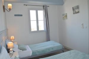 a bedroom with two beds and a window at Maison de charme La Flotte en Ré in La Flotte