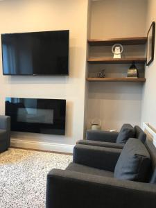 a living room with two couches and a flat screen tv at Beautiful 2 Bedroom Ballsbridge Apartment near the Aviva in Dublin