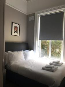 a bed in a bedroom with a window with towels on it at Beautiful 2 Bedroom Ballsbridge Apartment near the Aviva in Dublin
