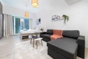 a living room with a couch and a bed at Stylish and Classy Studio in JLT in Dubai
