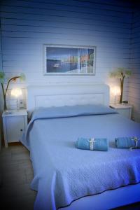 ein Schlafzimmer mit einem großen weißen Bett mit zwei blauen Kissen in der Unterkunft Timone d’oro in Gela