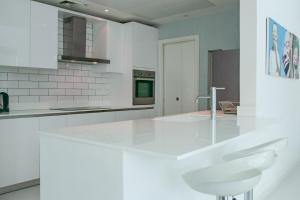 a white kitchen with a large white counter top at Cozy 1 Bedroom with Dubai Eye and sea views minutes to beach in Dubai