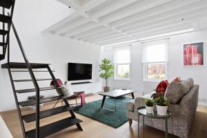 a living room with a ladder and a couch at Stylish Modern 2 Bedroom Apartment near Shoreditch in London